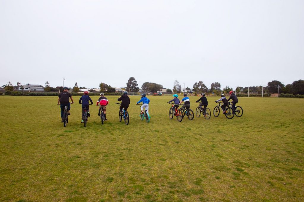 An instructor and some students ride across a field in Torquay