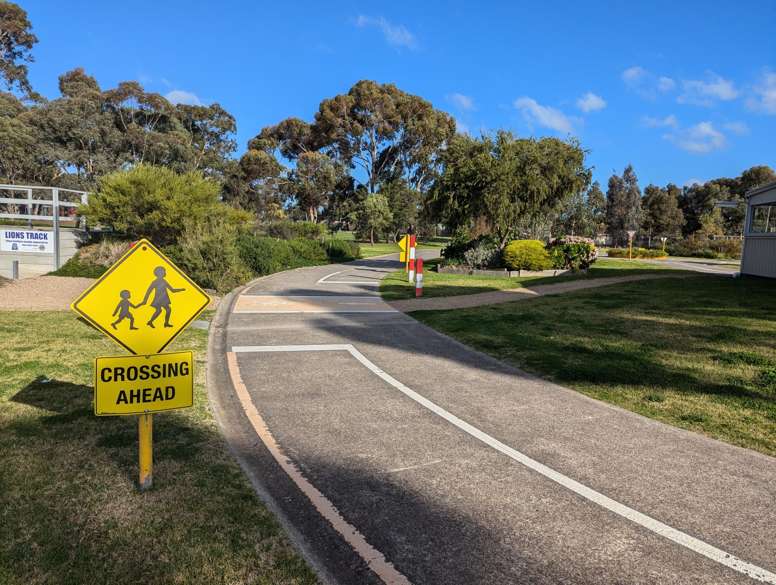 Mini road in parkland with Crossing Ahead sign