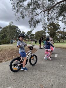 Children sitting on bikes learning to ride session